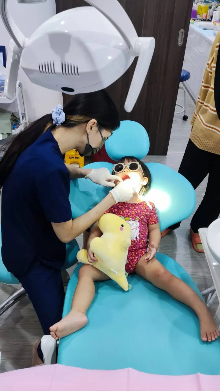 Child being treated in our paediatric dental chair with sunglasses and a comfort toy, keeping young patients calm during treatment