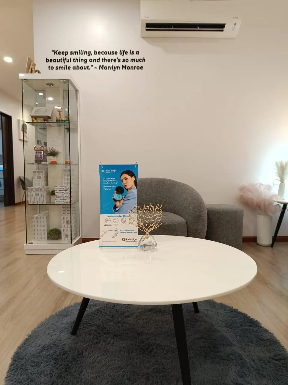 Quiet consultation lounge with armchair, coffee table and an Invisalign clear aligner information display for treatment discussions