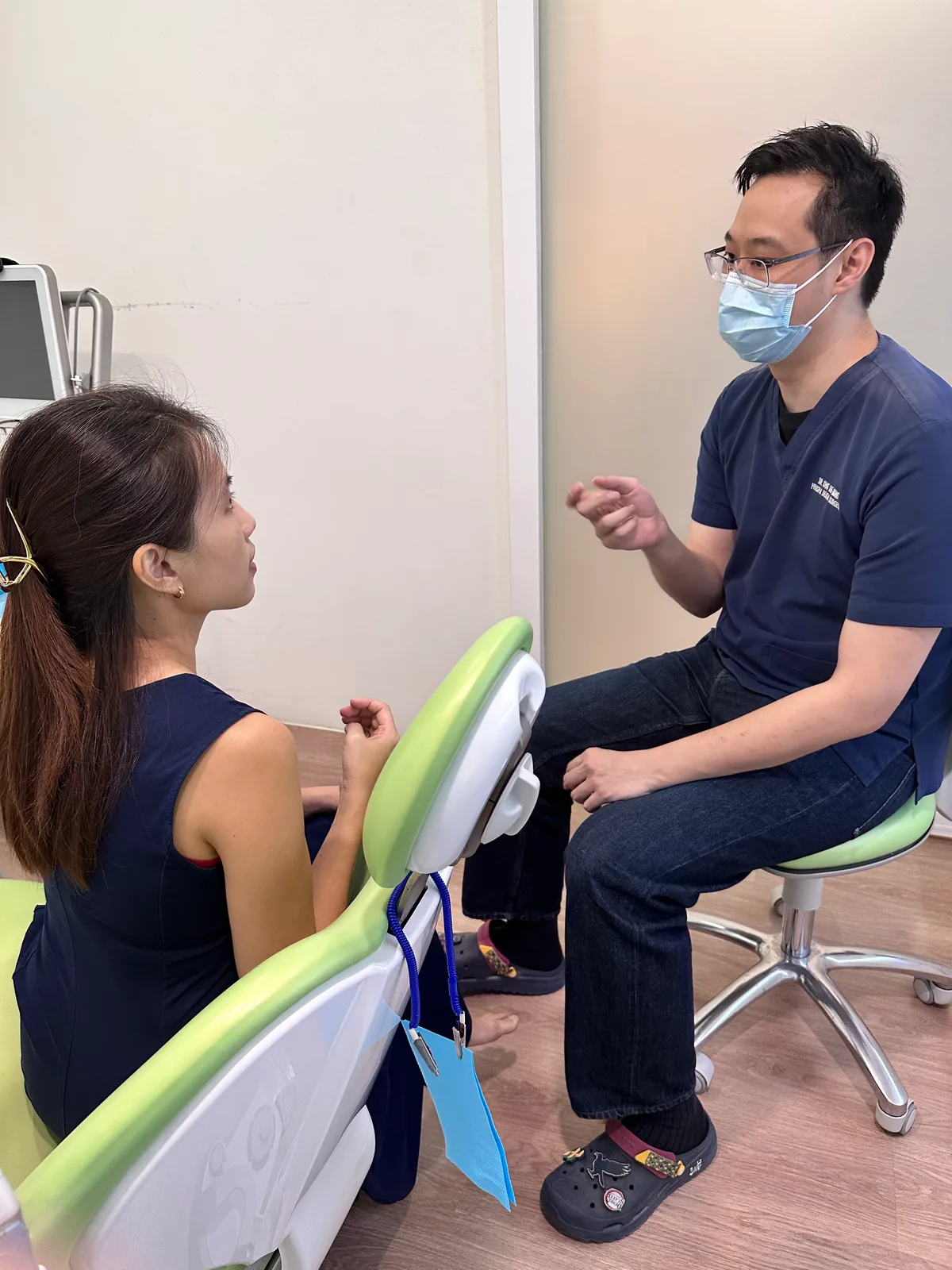 Dr. Ong De Ming explaining treatment options to a patient seated in the dental chair during a consultation at our Bukit Jalil clinic