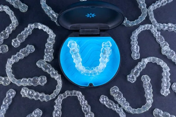 Set of Invisalign aligner trays laid out around their case, showing the series of aligners that gradually move teeth into place