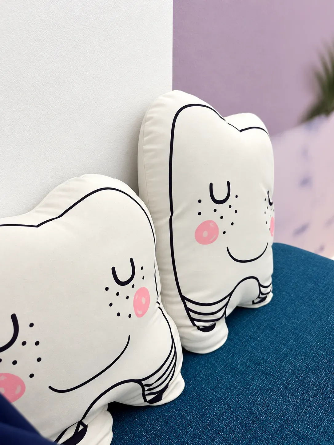 Smiling tooth-shaped comfort cushions on the waiting lounge sofa at Lau & Su Partners Dental, a small touch that puts nervous patients at ease in Bukit Jalil